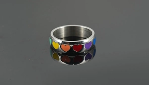 Detailed macro view of rainbow enamel heart patterns on a polished stainless steel ring band