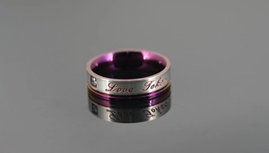 Vue macro de la bague en titane avec gravure Love Token, extérieur argenté et intérieur violet