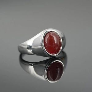 Polished silver titanium steel ring featuring an oval red agate stone inlay on a black surface