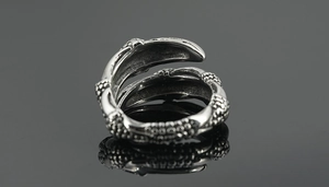 Gros plan sur la texture d'écailles de dragon vintage d'une bague ouverte en acier titane