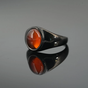 Polished black titanium steel signet ring with a large oval orange agate stone inlay