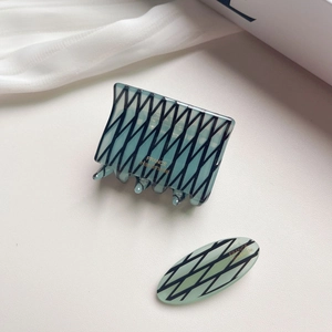 Set de pinces à cheveux en acétate turquoise avec lignes noires et logo doré