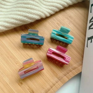 Set of four premium colorful acetate hair claws with marble texture in a soft setting