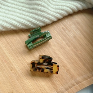 Detail showing acetate hair claws with marble textures and creation france logo engraving