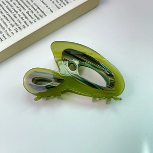 Détail de la pince à cheveux en acétate vert olive avec motif marbré et texte fait main
