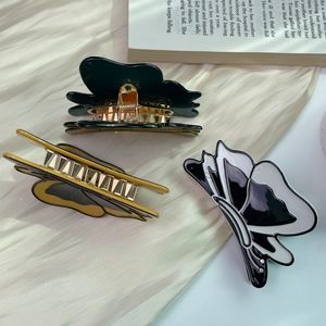 Three elegant acetate butterfly hair claws in green, yellow and marble on silk