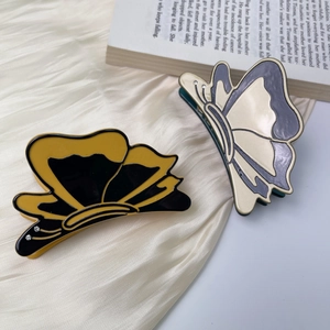 Elegant 3D butterfly hair claw clips in acetate resin with rhinestones on white velvet