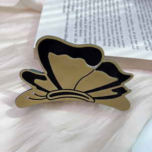 Detail view of acetate butterfly hair claw clip with crystal accents on satin fabric