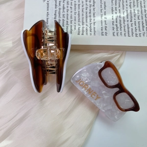 Chic tortoiseshell acetate hair claw clip with JORNEY lettering on vintage book pages