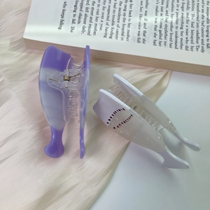 Close-up of pastel purple and pearl white acetate hair claws with pink rhinestone hearts