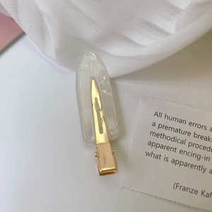 Detailansicht einer perlmuttartigen Acetat-Haarklammer mit schimmerndem Glanzeffekt