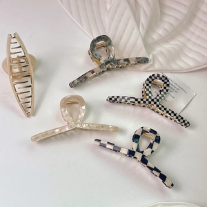 Détails d'un lot de cinq pinces à cheveux en acétate et métal aux motifs variés et élégants