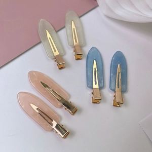 Elegante Haarspangen aus Marmor-Acetat in Rosa Blau und Creme auf sanftem Hintergrund