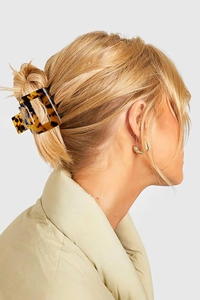 Mannequin portant une pince à cheveux léopard et des créoles dorées sur cheveux blonds