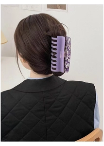 Detail of large acetate hair claw clip in lavender and marble pattern on hairstyle