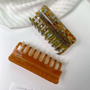 Vintage marble and amber acetate hair claw clips for thick hair shown on a white desk