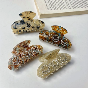 Acetate smiley face hair claws with rhinestones in tortoiseshell and marble patterns