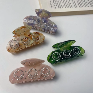 Set of four stylish acetate hair claws with sparkling rhinestone smiley faces