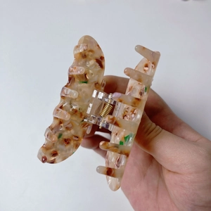 Detail showing high-quality acetate hair claw with mosaic pattern and metal spring