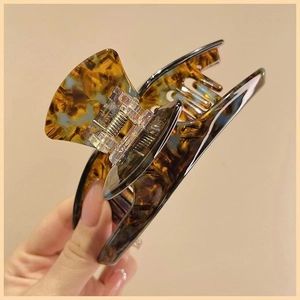 Macro detail of large tortoiseshell acetate hair claw clip with strong metal spring mechanism