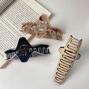 Detailed view of large acetate shark hair claws in tortoise shell and solid colors