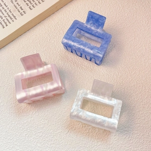 Pink and blue rectangular acetate hair claws with marble texture in a styled arrangement
