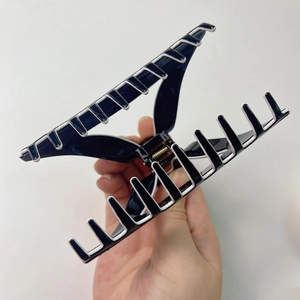 Large black and white acetate shark hair claw clip with cutout triangle design and rhinestones