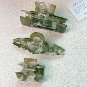 Detailed set of three olive green acetate hair claws with elegant marble patterns