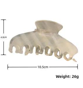 Detailed view of cream marble acetate hair claw clip with smooth rounded teeth and large size
