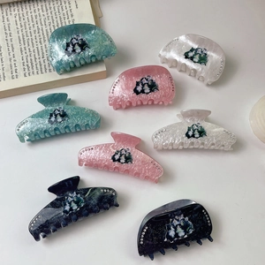 Detail showing acetate cat print hair claws with rhinestone accents in various colors