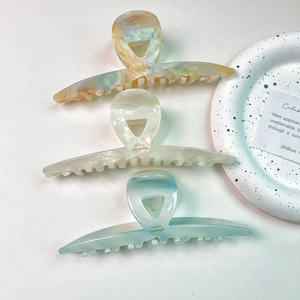 Detailed macro view of three 13cm acetate hair claws featuring marble texture and France label