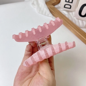 Detailed view of pink marble resin hair claw clip with metallic spring for thick hair