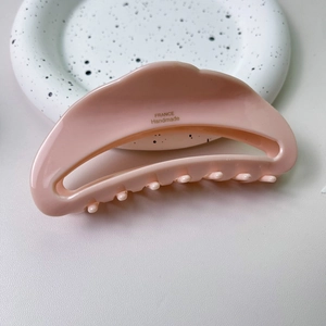 Vue détaillée de la pince à cheveux en acétate pêche avec inscription dorée France