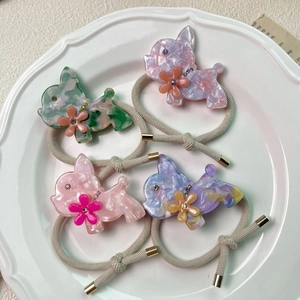 Detailansicht von vier pastellfarbenen Hunde-Haargummis mit Blumen- und Kristallakzenten