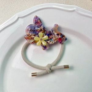 Detail von niedlichem Welpen-Haargummi mit glitzernder Strassblume auf elastischem Seil