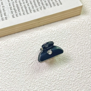 Close-up of black mini acetate hair claw clip with a sparkling centered rhinestone