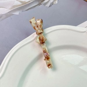 Detailed macro view of the marble texture on the acetate bow-knot duckbill hair clip