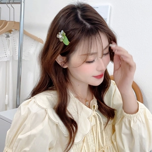 Gros plan détaillé d'une pince à cheveux fleur verte avec cristaux sur un mannequin