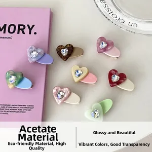 Detail of heart-shaped acetate hair clips with inlaid rhinestones in multiple colors