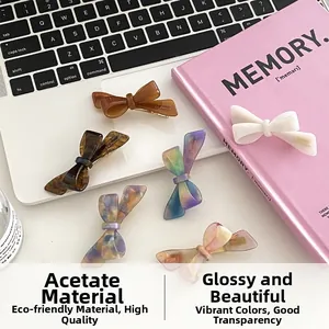 Detail of colorful acetate bow hair clips on a laptop, showing glossy texture and metal clips