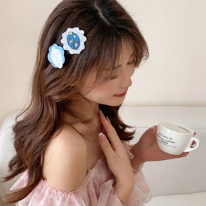 Gros plan de barrettes à cheveux en acétate avec des motifs abstraits et de planètes