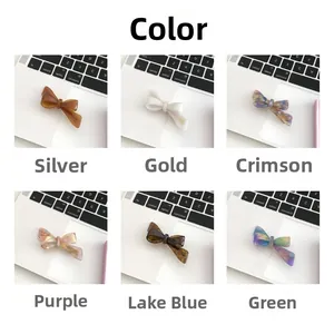Close-up of acetate bow hair clips in six marble colors with gold letter details