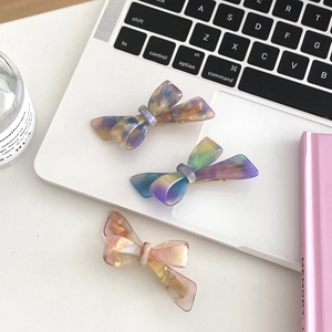 Detailed view of handmade acetate bow hair clips with marble texture in three colors