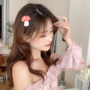 Cute red and white mushroom acetate hair clip worn by a model for a creative aesthetic style