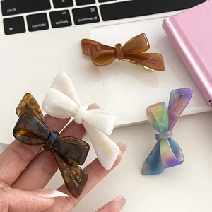Chic acetate bow hair clip set in amber, pearl white, and tortoiseshell patterns