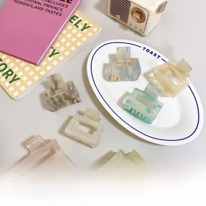 Rectangle acetate hair claws in marble patterns displayed with lifestyle props