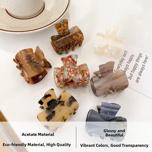 Macro detail of various tortoiseshell pattern acetate hair claw clips on white table