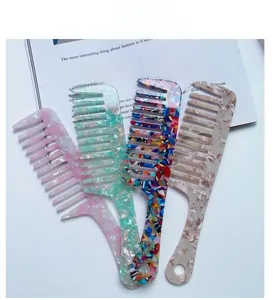Macro display of four acetate wide-tooth hair combs in various marble and floral patterns