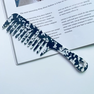 Detail of marble pattern acetate wide-tooth comb with geometric handle on magazine