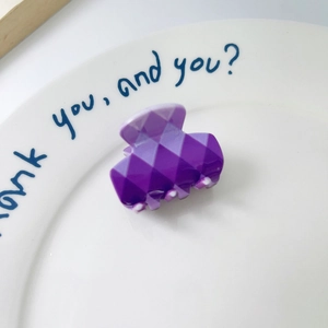 Detailed view of mini purple gradient rhombus geometric hair claw clip on ceramic dish